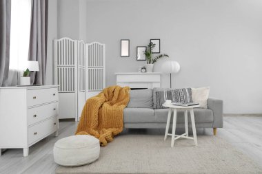 Gri kanepeli, masalı ve katlanır perdeli oturma odasının içi.