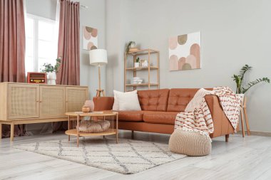 İçinde kahverengi kanepe, masa ve perdeler olan oturma odası.