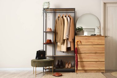 Ayna, çekmece sandığı ve koridorun içinde paltolar.