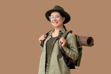 Bej arka planda sırt çantası olan genç bir bayan turist.