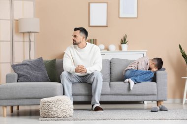 Evdeki kanepede tartıştıktan sonra ağlayan oğluyla baba.