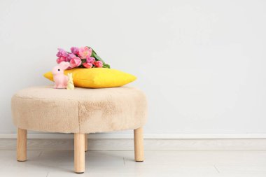 Lale çiçekleri ve tavşancıklar beyaz duvarın yanında, yakın plan. Paskalya kutlaması