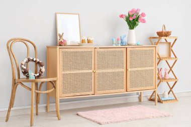 Sandalyesi, ahşap dolabı ve Paskalya süslemeleri olan festival salonu.