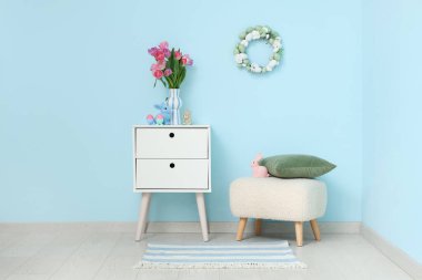 İçinde masa, puf ve Paskalya süslemeleri olan festival salonu.