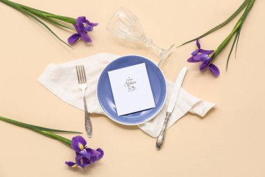 Tebrik kartı ve bej arka planda Iris çiçekleri olan güzel bir masa. Anneler Günü kutlaması