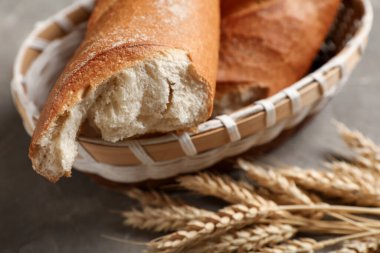 Gri arka planda taze baget ve buğdaylı hasır kase, yakın plan.