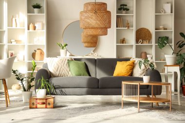 Gri kanepesi, sehpası ve aynası olan şık bir oturma odası.