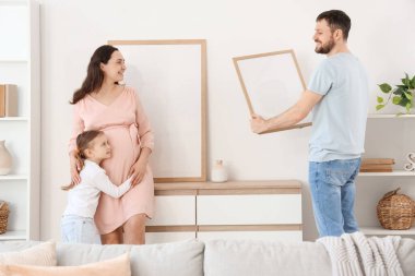 Mutlu aile evdeki ışık duvarına boş bir çerçeve asıyor.