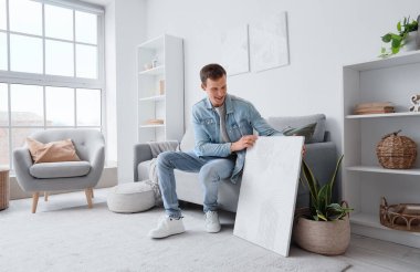 Evdeki kanepede oturan boyalı genç adam.