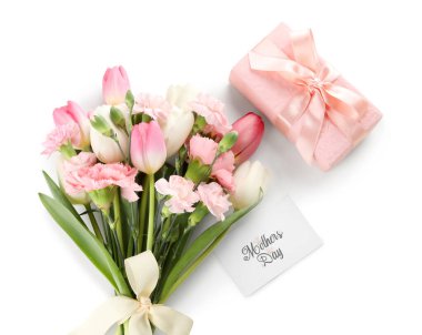 Farklı çiçeklerden oluşan bir buket hediye kutusu ve beyaz arka planda tebrik kartı. Anneler Günü kutlaması