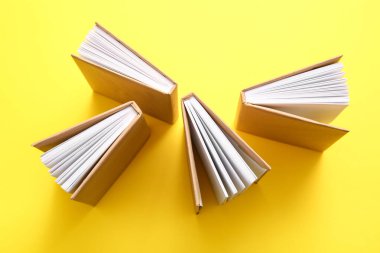 Sarı arkaplan üzerine açık kitaplı kompozisyon