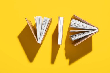 Sarı arkaplan üzerine kitapları olan kompozisyon