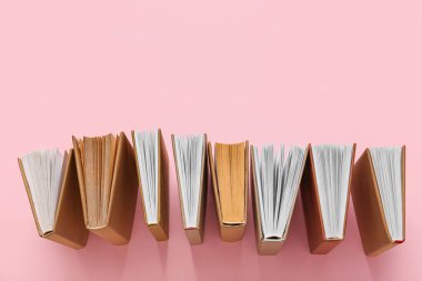 Pembe arkaplan üzerine birçok açık kitap