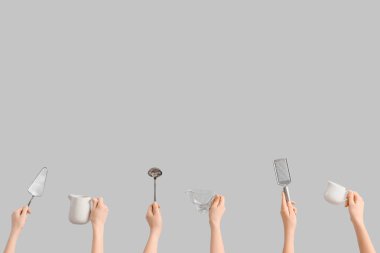 Gri arka planda mutfak aletleri olan kadın elleri