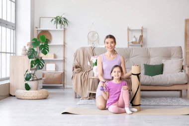 Sportif genç anne ve evde halterli ve yoga minderli sevimli küçük kızı. Anneler Günü kutlaması