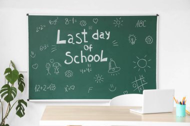 Okulun son günü yazılı karatahta ve sınıfın aydınlık duvarına çizimler