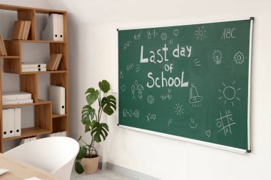 Okulun son günü yazılı karatahta ve sınıfın aydınlık duvarına çizimler