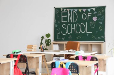 Okulun sonu yazılı karatahta ve sınıfın iç tarafındaki aydınlık duvarda çizimler