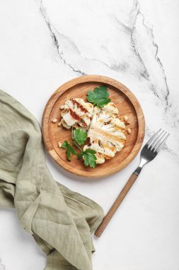 Ahşap tabak ızgara karnabahar bifteği maydanozlu ve fındıklı beyaz arka plan