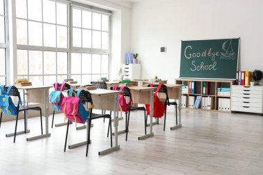 GOODBYE OKULU yazılı karatahta ve sınıf içi aydınlık duvara çizilmiş tekne