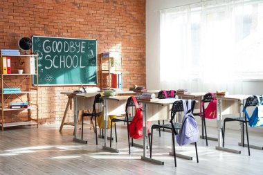 Sınıf içindeki tuğla duvarlara ve çizimlere GOODBYE OKULU yazılı kara tahta