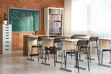 Sınıf içi tuğla duvarda yazılı yazı tahtası var.