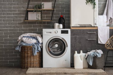 Çamaşır makinesi, kurutma makinesi ve gri tezgahı olan şık bir çamaşırhane.