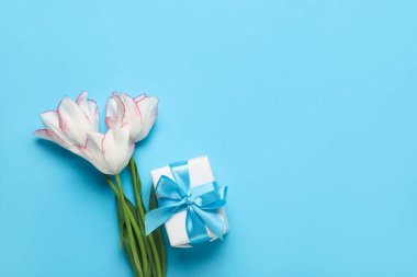 Güzel lale çiçekleri ve mavi arka planda hediye kutusu. Anneler Günü kutlaması