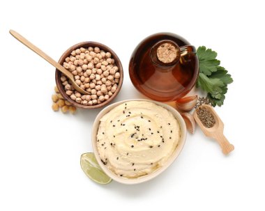 Beyaz arka planda malzemeleri olan lezzetli humus kasesi.