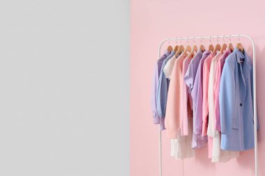 Pembe duvara karşı şık kadın kıyafetleriyle dizilin.