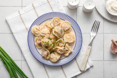 Beyaz fayanslı yeşil soğanlı kaynamış hamur köftesi tabağı.