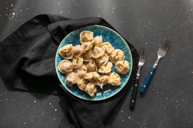 Siyah arkaplanda yeşil soğanlı lezzetli haşlanmış hamur köfteleri.