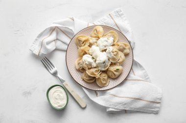 Beyaz arka planda ekşi kremalı lezzetli kaynamış hamur köfteleri.