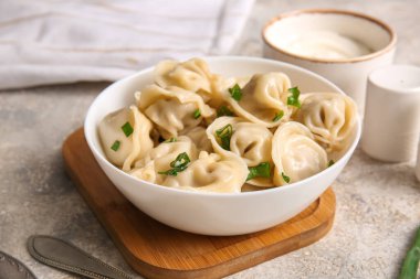 Bir kase lezzetli haşlanmış hamur köftesi, yeşil soğanlı ve ekşi kremalı, yakın plan.