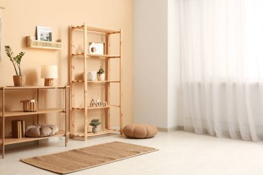 Oturma odasında ahşap masa ve süslemeli raf.