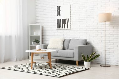 Masalı gri kanepe ve aydınlık oturma odasında lambalar.