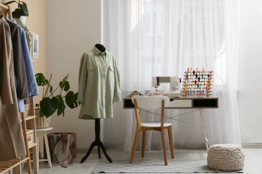 Atölye içindeki terzinin iş yeri ve vitrinin yanındaki manken