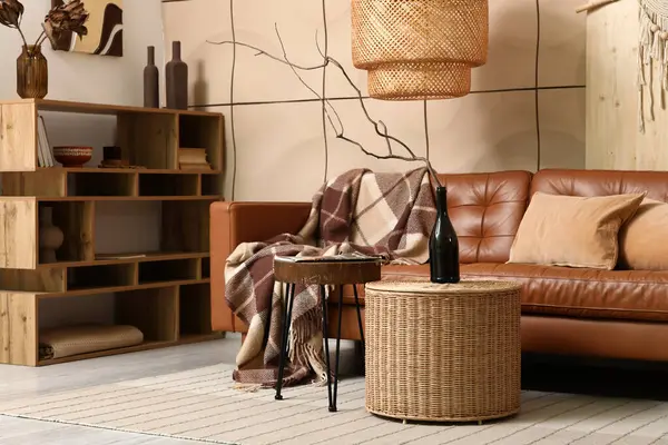 Rahat bir kanepe, raf ünitesi ve şişesi oturma odasının içinde.