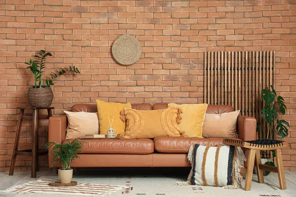 Rahat bir kanepe, minderli bir tabure ve oturma odasının iç tarafında bitkiler.