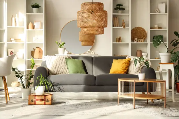 Gri kanepesi, sehpası ve aynası olan şık bir oturma odası.