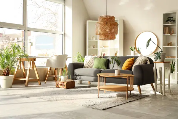 Gri kanepesi, sehpası ve aynası olan şık bir oturma odası.