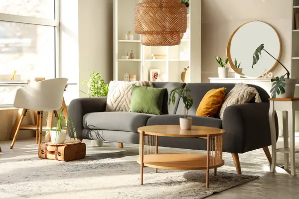 Gri kanepesi, sehpası ve aynası olan şık bir oturma odası.