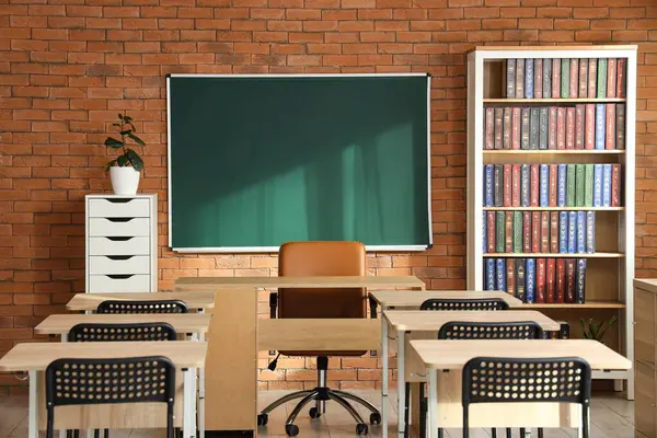 Sınıfın içindeki tuğla duvarda boş bir karatahta