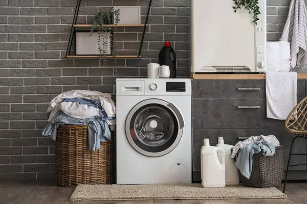 Çamaşır makinesi, kurutma makinesi ve gri tezgahı olan şık bir çamaşırhane.