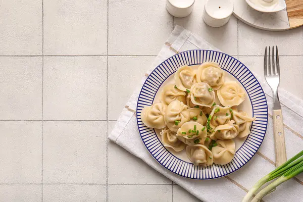 Beyaz fayanslı yeşil soğanlı kaynamış hamur köftesi tabağı.