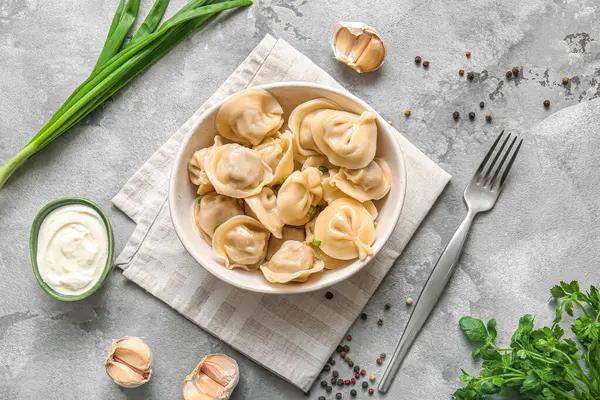 Yeşil soğanlı, sarımsaklı ve ekşi kremalı bir kase lezzetli haşlanmış hamur köftesi.