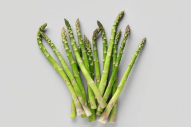 Gri arkaplanda taze yeşil kuşkonmaz