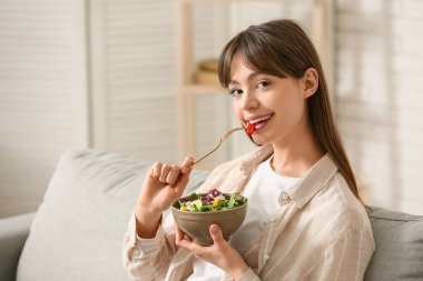 Genç kadın evde taze sebze salatası yemek