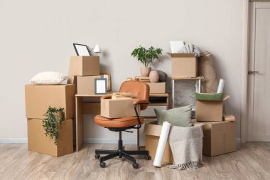 Taşındığı gün ışık duvarının yanında karton kutular olan çalışma yeri