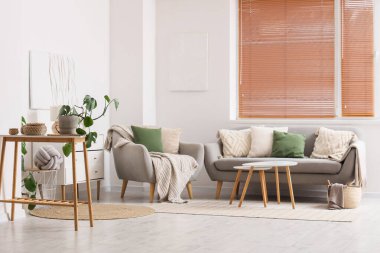 Kanepesi, koltuğu ve penceresinde panjuru olan bir oturma odası.